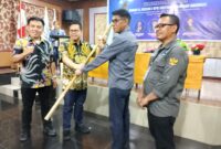 Caption: Ketua Dewan Pakar DPP PJS, Rizaludin Kurniawan saat menyerahkan Pataka PJS kepada Ketua DPP PJS Terpilih Mahmud Marhaba usai Munas II, Palu (13/07/2025).
