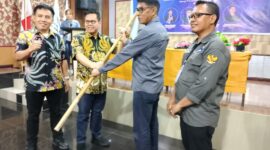 Caption: Ketua Dewan Pakar DPP PJS, Rizaludin Kurniawan saat menyerahkan Pataka PJS kepada Ketua DPP PJS Terpilih Mahmud Marhaba usai Munas II, Palu (13/07/2025).
