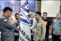 Caption: Mahmud Marhaba menyerahkan Pataka PJS kepada Ketua DPD PJS Sulteng Muhammad Sofyan, Minggu (13/07/2025).