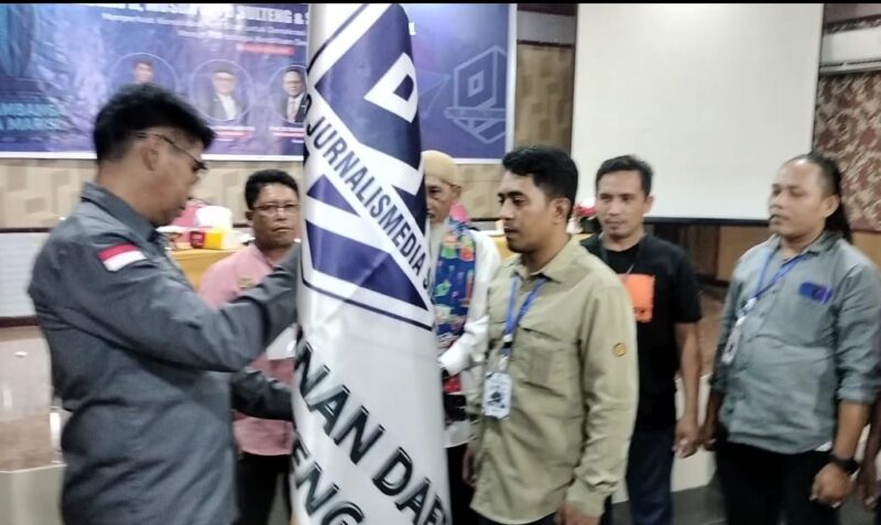 Caption: Mahmud Marhaba menyerahkan Pataka PJS kepada Ketua DPD PJS Sulteng Muhammad Sofyan, Minggu (13/07/2025).