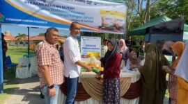 Caption : SEVP Business Support PTPN IV regional 6 Ifri Handi Lubis menyerahkan beras SPHP langsung ke pembelinya