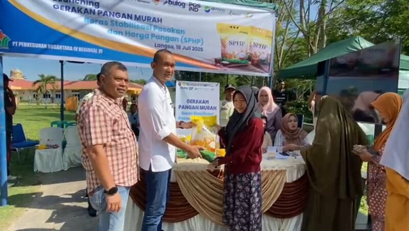 Caption : SEVP Business Support PTPN IV regional 6 Ifri Handi Lubis menyerahkan beras SPHP langsung ke pembelinya