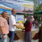 Caption : SEVP Business Support PTPN IV regional 6 Ifri Handi Lubis menyerahkan beras SPHP langsung ke pembelinya