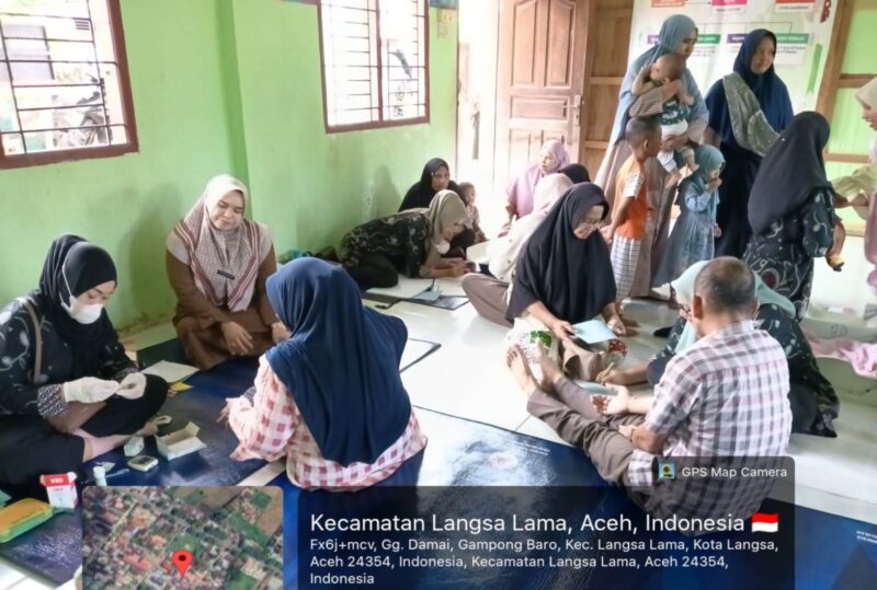 Caption: Warga Gampong Baro sedang mengecek kesehatan dan Imunisasi balita di Posyandu.