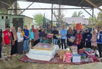 Caption: Penyerahan bantuan secara simbolis oleh Pelaksana Tugas (Plt) Kepala Dinas Sosial Kota Langsa, Sopian didampingi oleh jajaran terkait kepada Geuchik Gampong Blang, Junaidi.