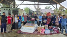Caption: Penyerahan bantuan secara simbolis oleh Pelaksana Tugas (Plt) Kepala Dinas Sosial Kota Langsa, Sopian didampingi oleh jajaran terkait kepada Geuchik Gampong Blang, Junaidi.
